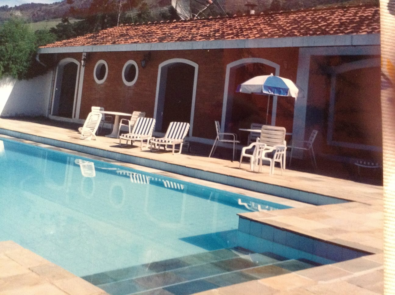 Área de lazer completa com piscina e estrutura coberta